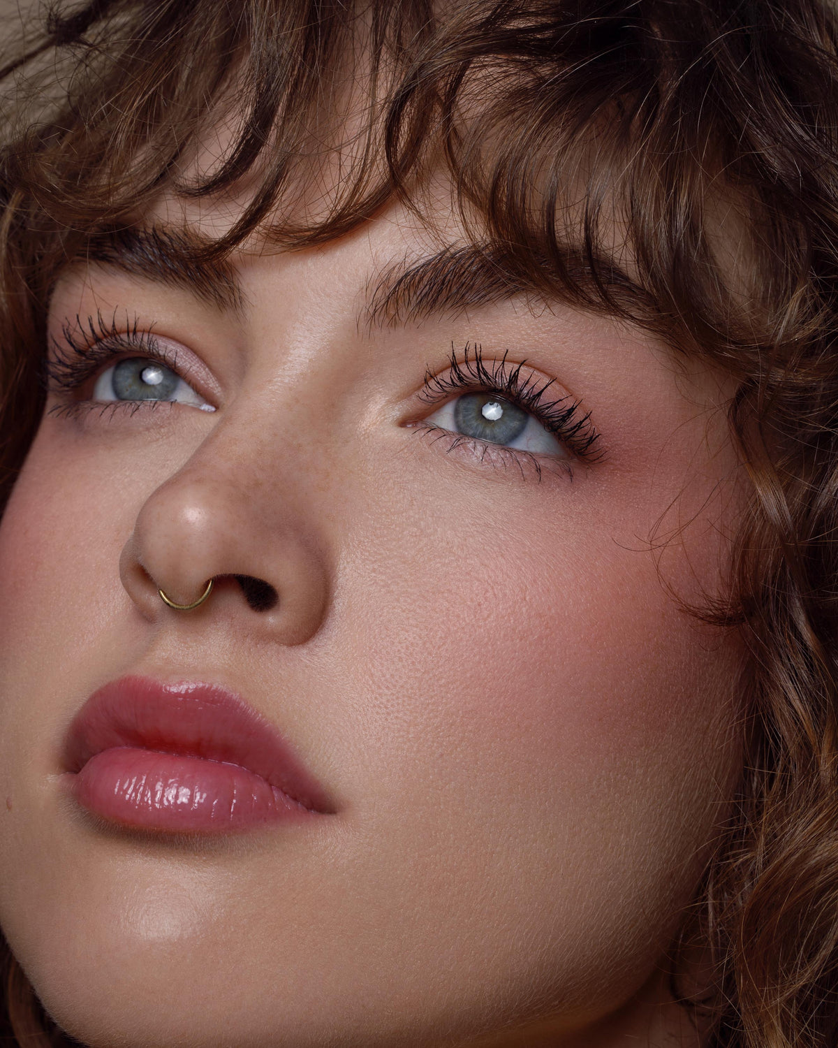 Close-up of a model with light skin wearing pink lipstick and blush